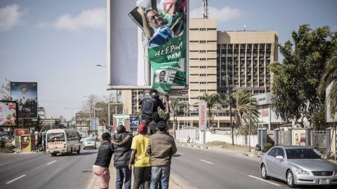 Supporters of Zambian President elect for the opposition party United Party for National Development (UPND) Hakainde Hichilema remove a poster of the former president Edgar Lungu from a pole in Lusaka, on August 16, 2021. 