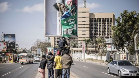 Supporters of Zambian President elect for the opposition party United Party for National Development (UPND) Hakainde Hichilema remove a poster of the former president Edgar Lungu from a pole in Lusaka, on August 16, 2021.