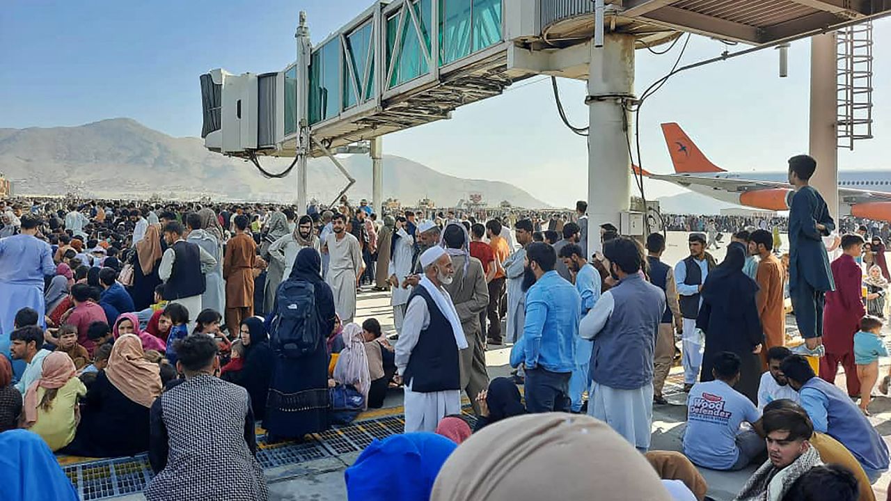 Afghans crowd the tarmac of Kabul's international airport on Monday.