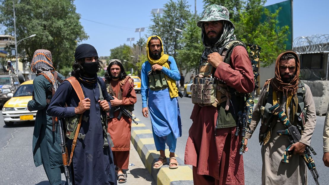Taliban fighters stand guard along a street near Zanbaq Square in Kabul.