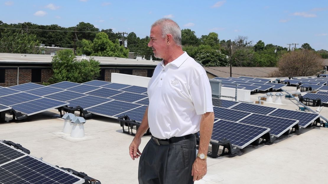 Matthew Haines, an independent rental owner near Dallas, inspects a solar array installed on top of one of his buildings earlier this summer.