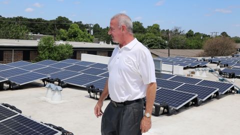 Matthew Haines, an independent rental owner near Dallas, inspects a solar array installed on top of one of his buildings earlier this summer.
