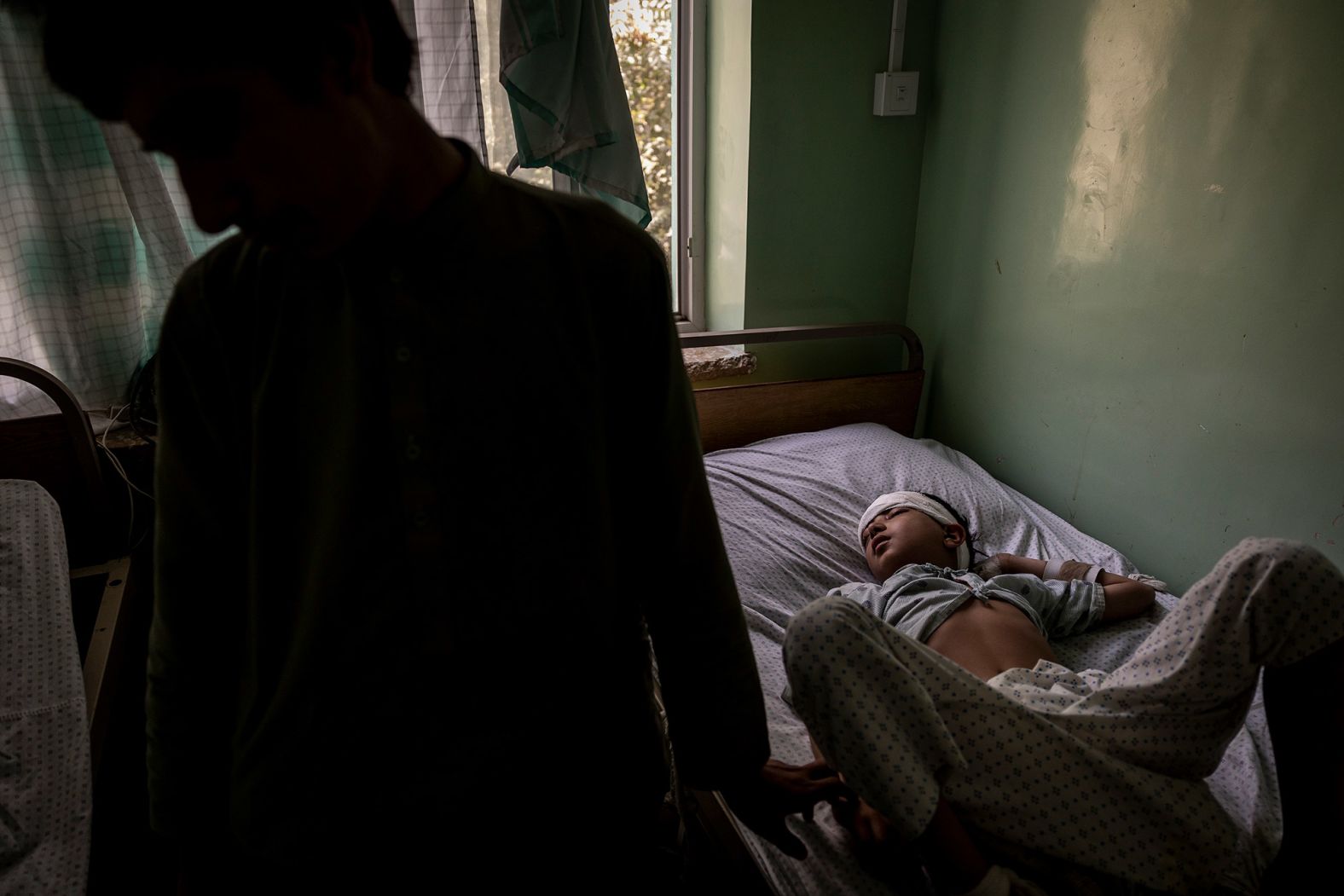 Hanif, who was struck in the temple by a stray bullet, and his older brother, Mohammed, are seen at the Mirwais Regional Hospital in Kandahar in August 2021. Kandahar had been under siege for a month, and it would soon fall to the Taliban.