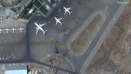 A satellite image from Maxar shows a crowd of people on the tarmac at Kabul International Airport, Afghanistan on Monday August 16, 2021. "While one Turkish airliner prepares to takeoff from the airfield, security forces can be seen near one of the airport's main runways attempting to prevent crowds of people from moving toward other aircraft and from blocking flight operations," Maxar says.  