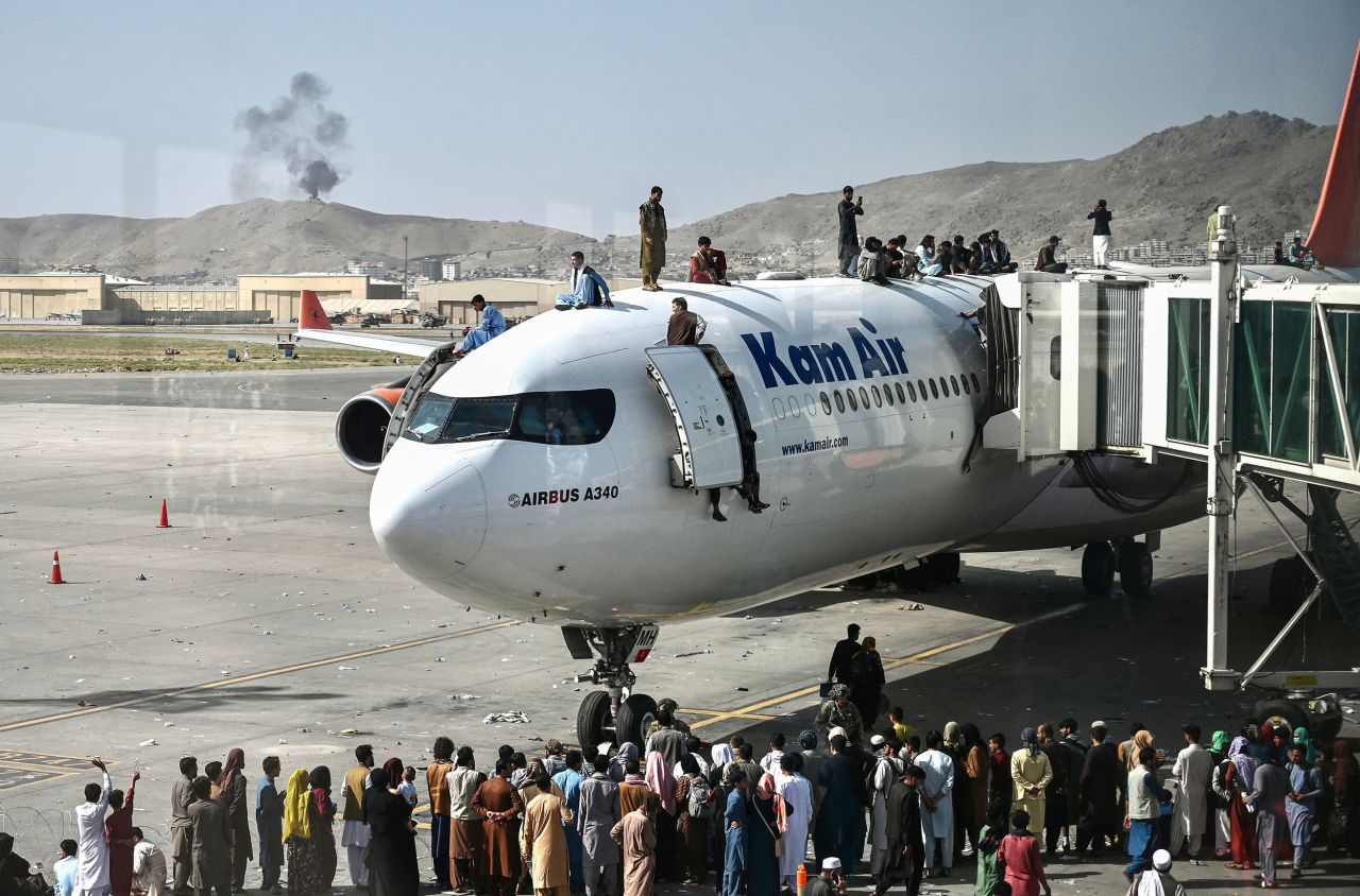 People climb atop a plane at the airport in Kabul on August 16. Hundreds of people<a href="https://www.cnn.com/2021/08/16/middleeast/kabul-afghanistan-withdrawal-taliban-intl/index.html" target="_blank"> were on the tarmac, trying to find a way out of the country.</a>