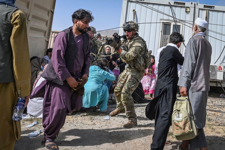 A US soldier points a gun while working to secure Kabul's airport on August 16. US Defense Secretary Lloyd Austin approved the deployment of 1,000 more American troops into the country due to the deteriorating security situation, a defense official told CNN, upping the number of troops in the country to 6,000.