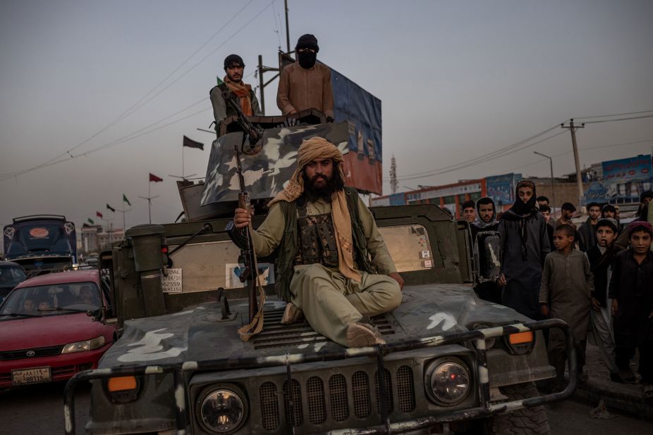 Taliban fighters ride a Humvee near a Kabul roundabout on August 15.