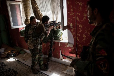 Afghan commandos look out from a window at a home in Kunduz on July 6. The Taliban were moving rapidly to take over districts in northern Afghanistan.