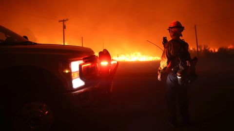 Firefighters monitor the Dixie Fire as it burns along Highway 395 on near Janesville, California.