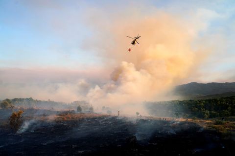 A helicopter drops water as a wildfire burns in the village of Navalmoral, Spain, on August 16. 