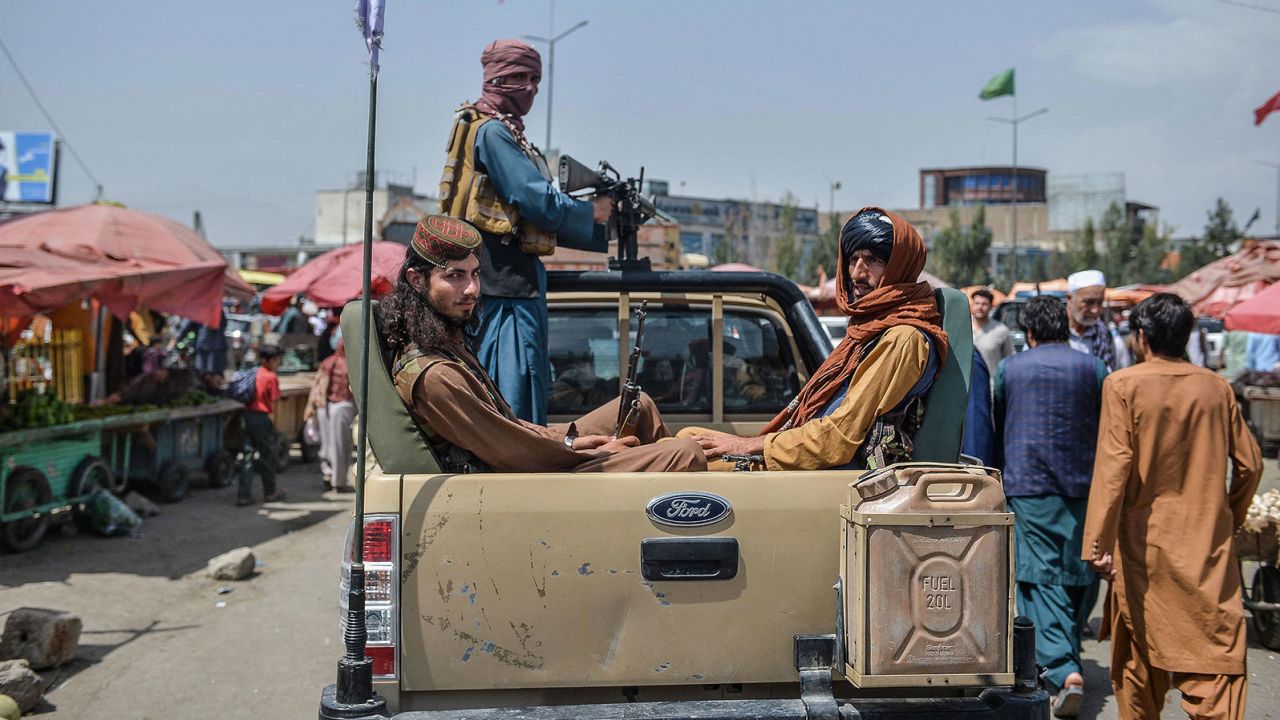 Taliban fighters on a pick-up truck move around a market in Kabul on Tuesday.