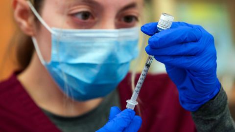 Alma Sevilla preparers a Pfizer vaccine vial at a mobile vaccine clinic in Los Angeles. 