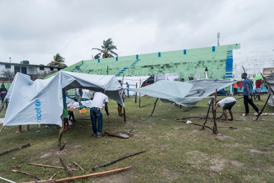 People build makeshift tents at a football stadium in Les Cayes after spending the night outside.