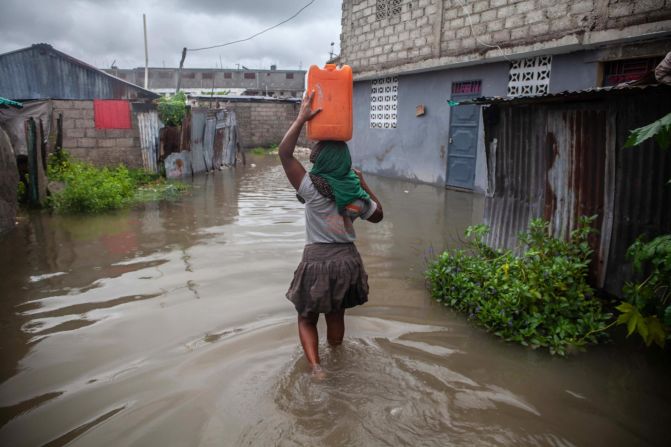 A woman walks in a flooded area of Les Cayes on August 17. <a href="index.php?page=&url=https%3A%2F%2Fwww.cnn.com%2F2021%2F08%2F17%2Famericas%2Fhaiti-earthquake-news-tuesday-intl%2Findex.html" target="_blank">Tropical Storm Grace</a> moved across the southern coast of Hispaniola, the island comprising Haiti and the Dominican Republic, just days after the earthquake. The storm "is further disrupting access to water, shelter, and other basic services," UNICEF said in a statement Tuesday. "Flooding and mudslides are likely to worsen the situation of vulnerable families and further complicate the humanitarian response."