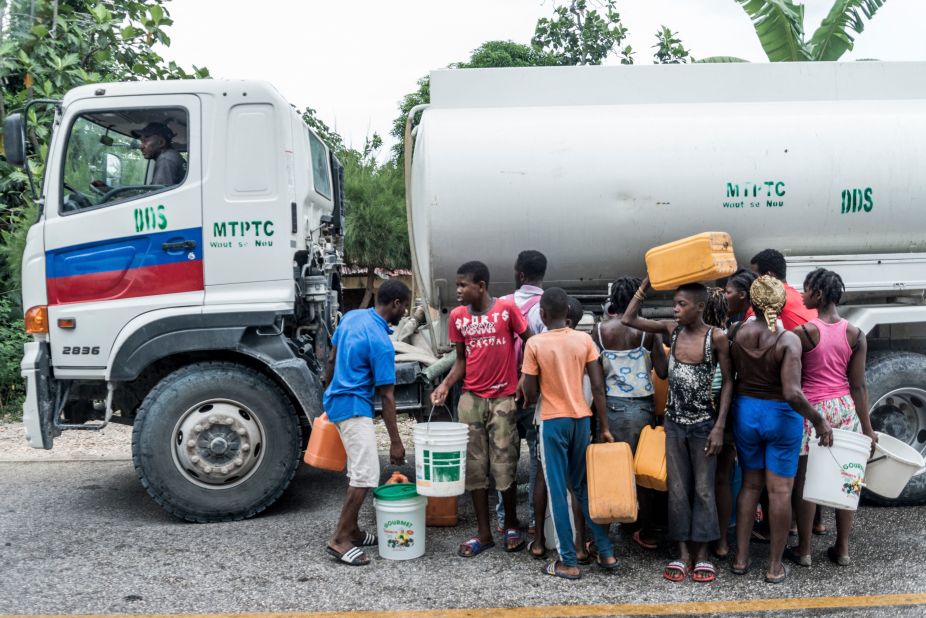 People wait to collect water in Camp-Perrin, Haiti, on August 16.