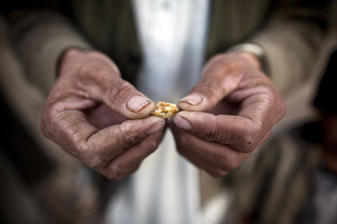An Afghan man holds a small piece of gold, prospected from the site of a proposed Qara Zaghan mine in 2011.