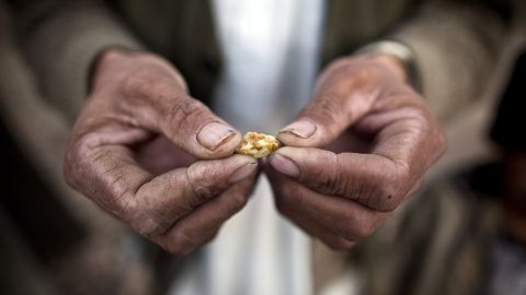 An Afghan man holds a small piece of gold, prospected from the site of a proposed Qara Zaghan mine in 2011.