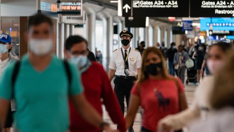 People wearing protective masks walks through Hartsfield-Jackson Atlanta International Airport.