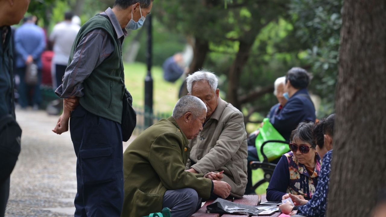 Senior citizens sit together while playing cards in Fuyang, China's Anhui province, on May 12.
