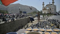 Youths feed pigeons near the Shah-Do-Shamshira Mosque in Kabul on August 18, 2021 following the Taliban stunning takeover of Afghanistan. (Photo by HOSHANG HASHIMI / AFP) (Photo by HOSHANG HASHIMI/AFP via Getty Images)