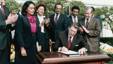 In the presence of Coretta Scott King, President Ronald Reagan signs a bill making Martin Luther King Jr.'s birthday a national holiday, November 2, 1983.