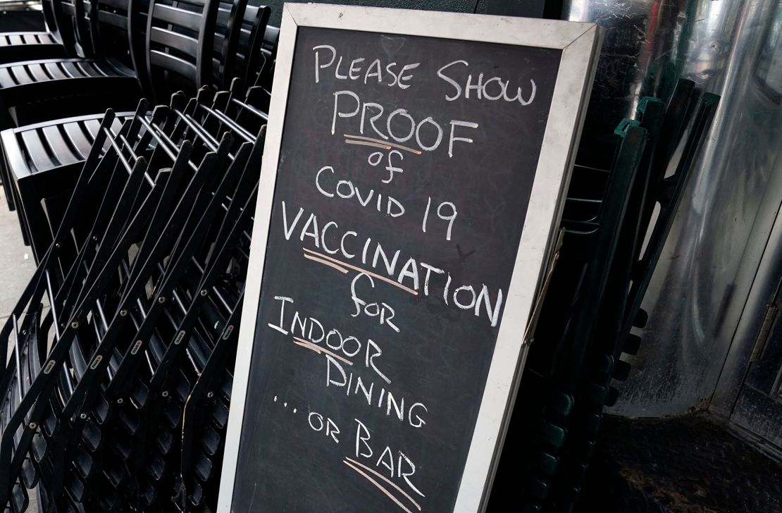 A sign at a NYC restaurant reads "Please show proof of Covid-19 vaccination for indoor dining ... or bar." 
