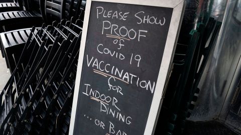 A sign at a NYC restaurant reads "Please show proof of Covid-19 vaccination for indoor dining ... or bar." 
