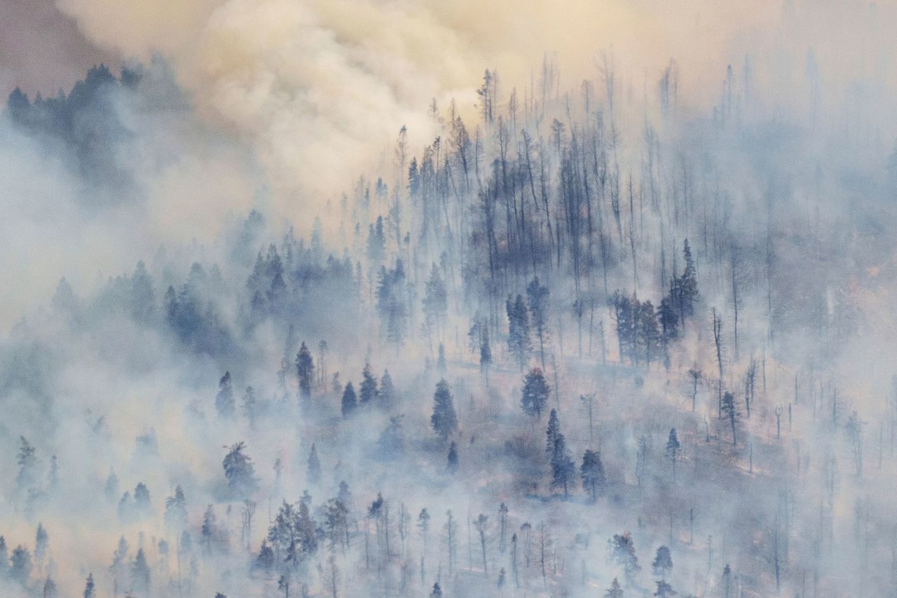 Wind blows smoke away for a moment, revealing damage from the Parleys Canyon Fire in Utah on August 14.