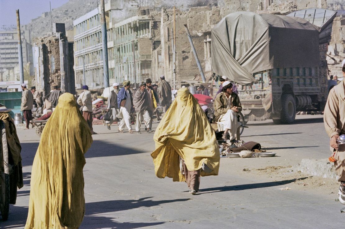 Two Afghan women, wearing yellow niqabs, walk in Kandahar, Afghanistan, 1996.