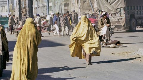 Two Afghan women,  wearing yellow niqabs, walk in Kandahar, Afghanistan, 1996. 