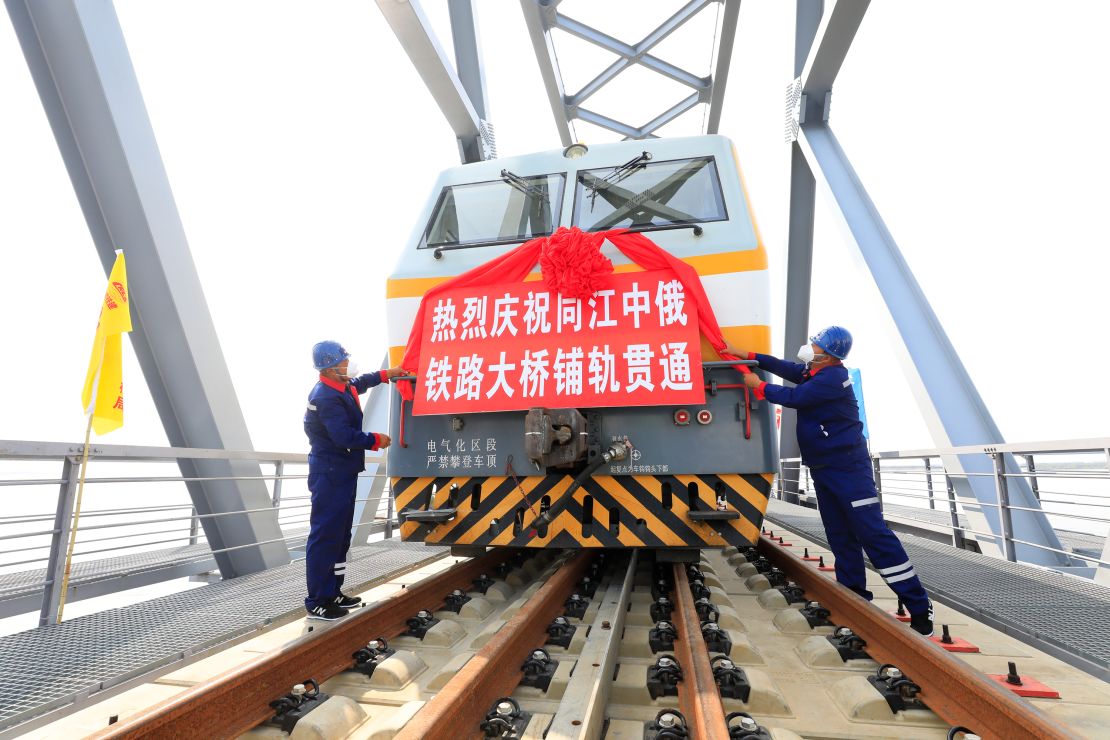 Workers celebrate laying the final pieces of track on the bridge.