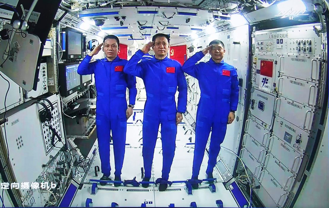 Chinese astronauts, from left Tang Hongbo, Nie Haisheng, and Liu Boming salute from aboard China's space station core module on June 23.