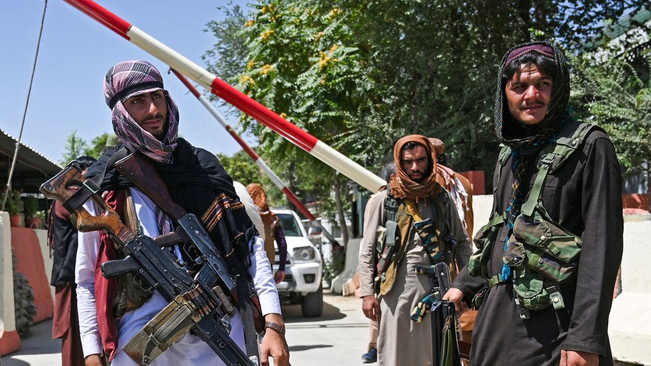 Taliban fighters stand guard along a roadside near the Zanbaq Square in Kabul on August 16, 2021.