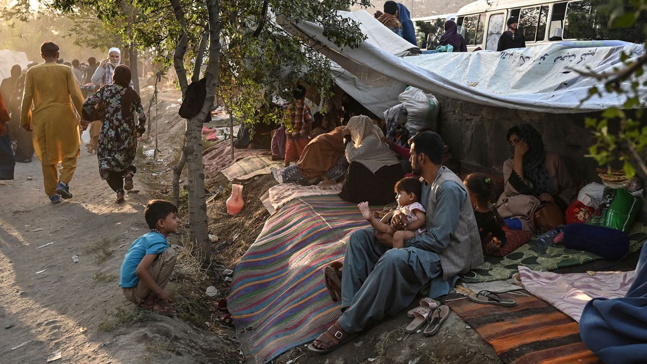 Displaced Afghan families, who fled from Kunduz, Takhar and Baghlan province due to battles between Taliban and Afghan security forces, sit in front of their temporary tents in Kabul on August 11, 2021.