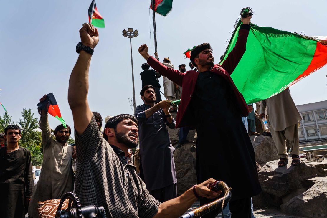 Afghans fly the national flag in Kabul on Thursday, despite the presence of Taliban fighters.