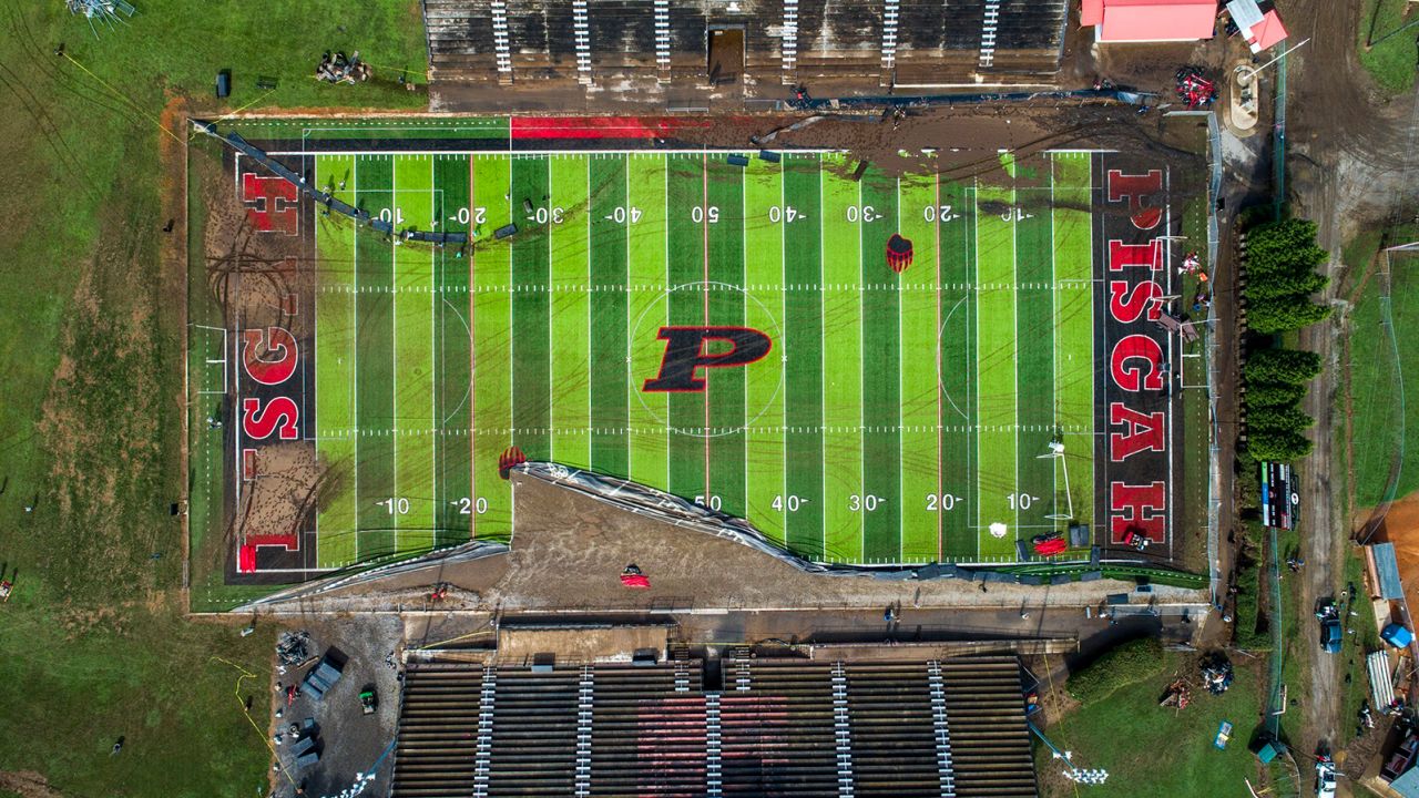 Volunteers on Thursday clear debris and try to salvage athletic equipment at the football field shared by Pisgah High School and Canton Middle School.