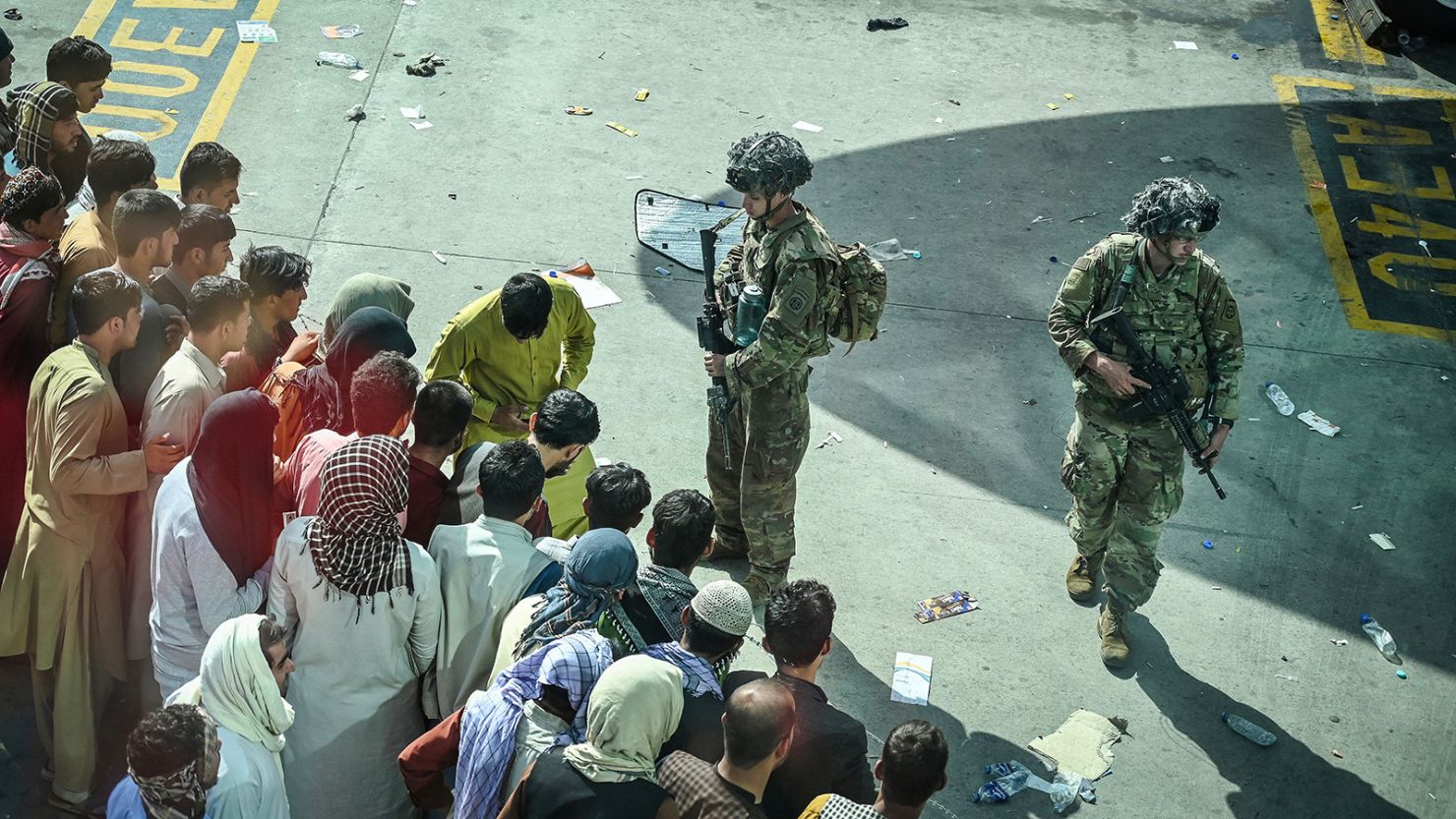 US soldiers stand guard as Afghan people wait at the Kabul airport in Kabul on August 16, 2021.