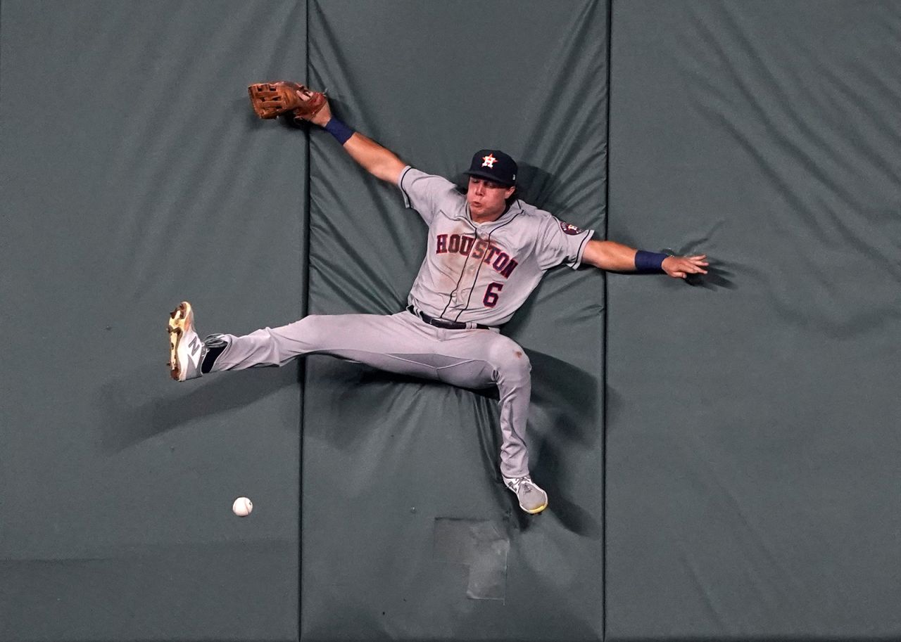 Houston's Jake Meyers collides with the outfield wall while trying to make a catch during a Major League Baseball game in Kansas City, Missouri, on Monday, August 16.
