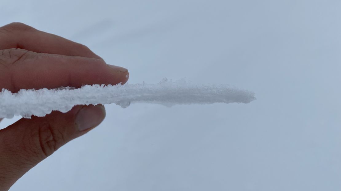 A Greenland researcher holds a thin piece of ice that formed when rain fell on top of the snow at the Greenland summit on Saturday.