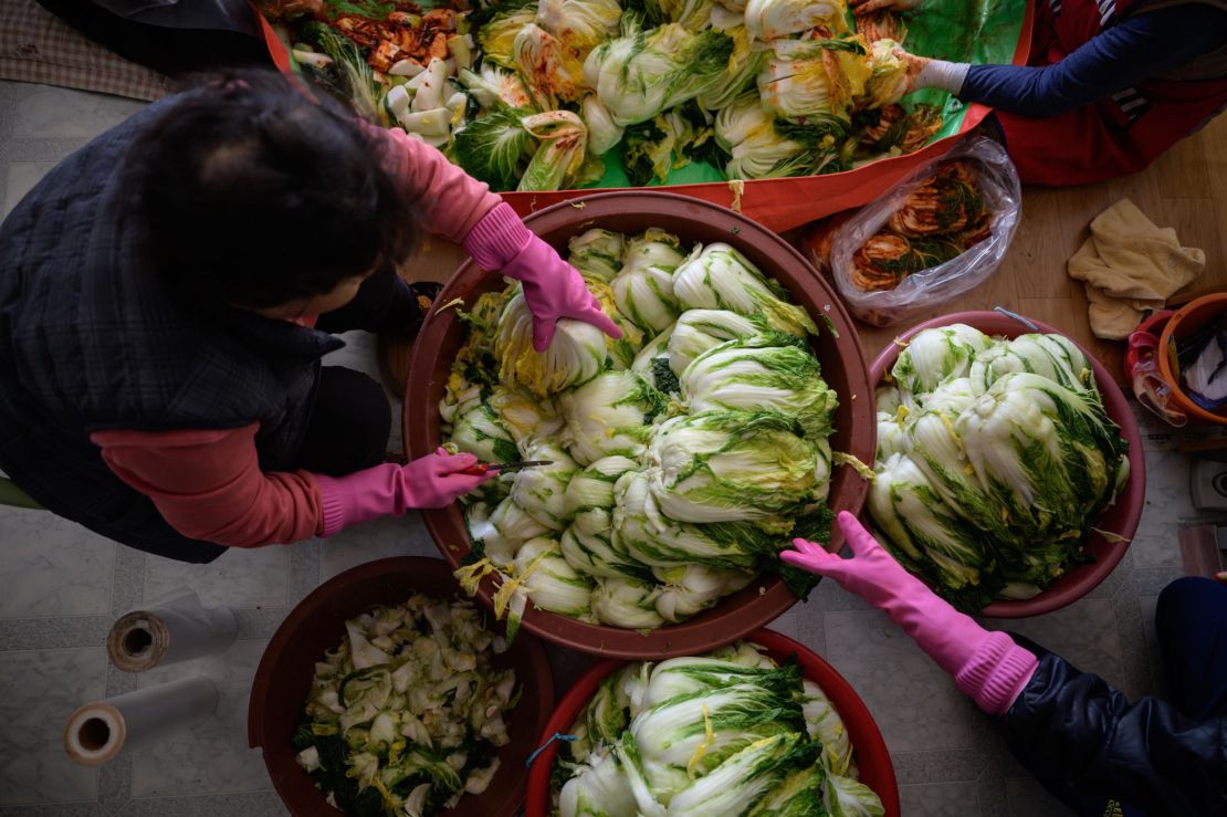 Women prepare cabbage to make kimchi during the traditional communal process known as 'kimjang.'
