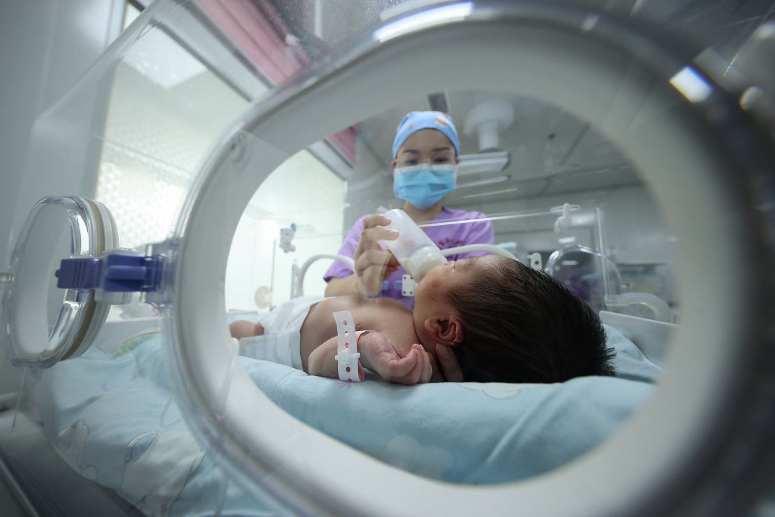 A medical staff member feeds a baby at a hospital in Danzhai, in China's southwestern Guizhou province on May 11, 2021. 
