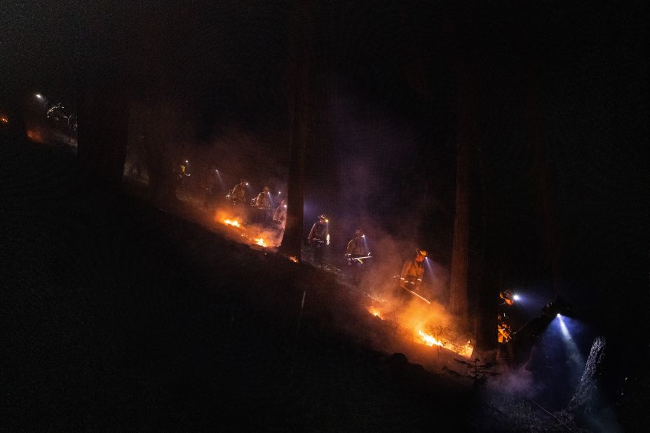 Firefighters dig a containment line on the Caldor Fire near Pollock Pines, California, on August 18.