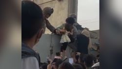 afghan man hands child to soldier orig