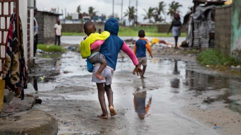 A child walks near rising waters in the Praia Nova neighborhood in Beira, Mozambique, a country where children are at 'extremely high risk' from the impact of the climate crisis. 