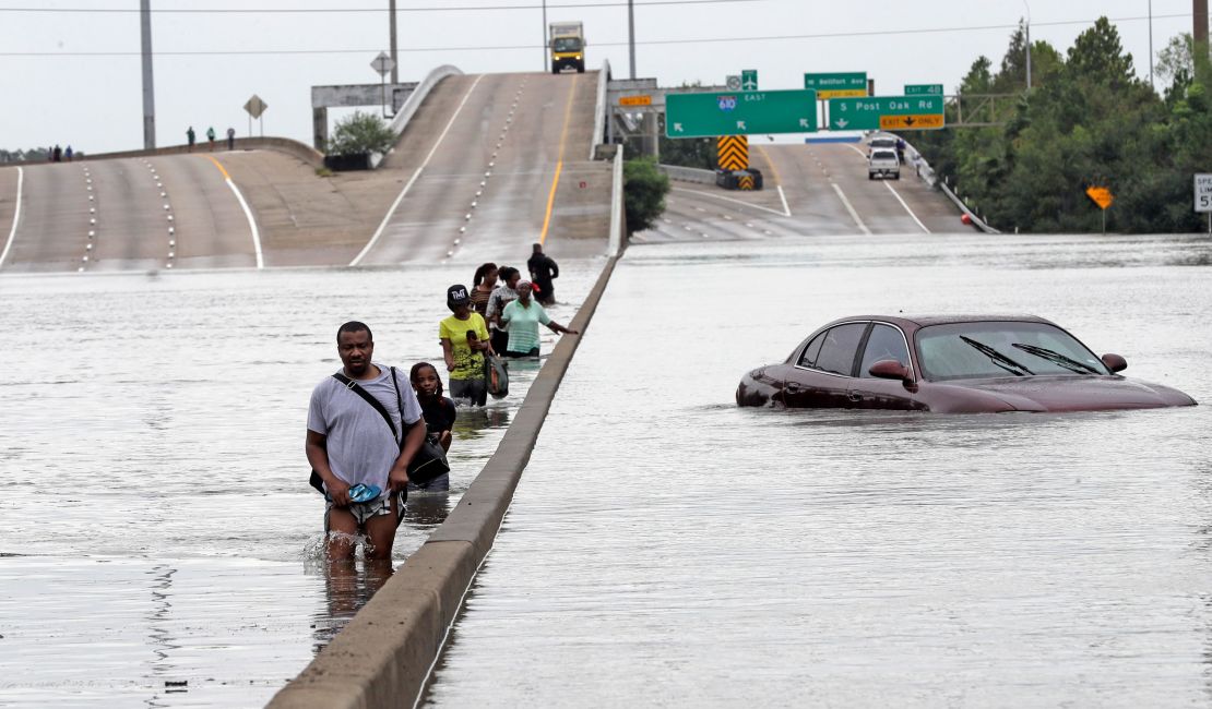 Evacuees wade down a submerged section of Interstate 610 in Houston after Hurricane Harvey in 2017 caused widespread flooding.