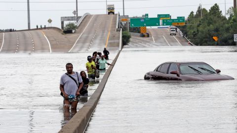 Evacuees wade down a submerged section of Interstate 610 in Houston after Hurricane Harvey in 2017 caused widespread flooding.