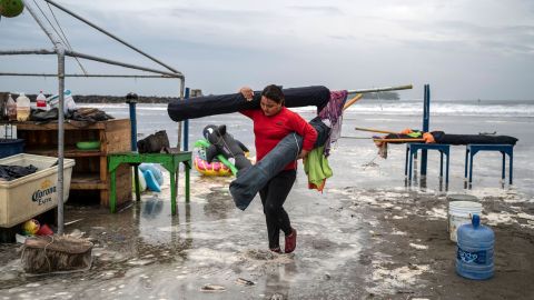 A woman removes umbrellas from the beach as strong waves reach the coast due to Hurricane Grace in Boca del Rio, Veracruz, Mexico, on August 20, 2021.
