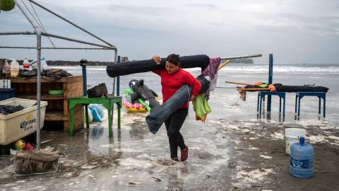 A woman removes umbrellas from the beach as strong waves reach the coast due to Hurricane Grace in Boca del Rio, Veracruz, Mexico, on August 20, 2021. 