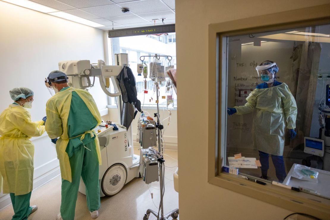 A registered nurse, right, closes the door as staff treat patients in the Covid ward at Ochsner Medical Center in Jefferson, Louisiana,  on  August  10, 2021.