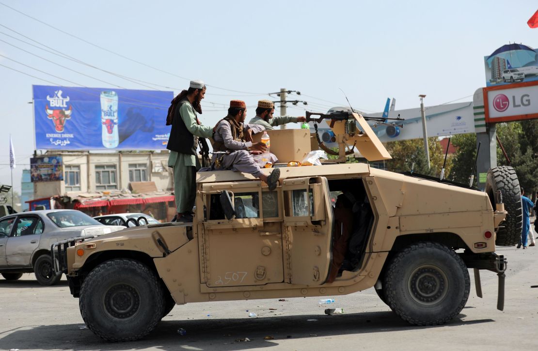 Taliban fighters stand guard in front of the Hamid Karzai International Airport, in Kabul, Afghanistan, Monday, Aug. 16, 2021. 